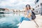 young beautiful woman traveler in a hat talking on a mobile phone on a beautiful port background on a sunny day by the sea.