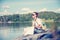 Young beautiful woman traveler with a map in hands sits on a lake in Norway