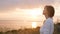 Young beautiful woman turning to God in nature, the girl praying folded her hands at the chin, concept of religion