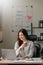 Young beautiful woman typing on tablet and laptop while sitting at the working wooden table office