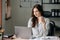 Young beautiful woman typing on tablet and laptop while sitting at the working wooden table office