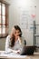 Young beautiful woman typing on tablet and laptop while sitting at the working wooden table office