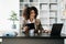 Young beautiful woman using laptop and tablet while sitting at her working place. Concentrated at work