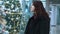 A young beautiful woman walks around the store and selects Christmas decorations and decorations to celebrate the New