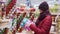 A young beautiful woman walks around the store and selects Christmas decorations and decorations to celebrate the New Year and Chr