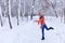 A young beautiful woman walks in winter along an alley in a snow-covered fabulous city park