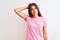 Young beautiful woman wearing pink casual t-shirt standing over isolated white background confuse and wonder about question