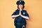 Young beautiful woman wearing police uniform praying with hands together asking for forgiveness smiling confident