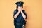 Young beautiful woman wearing police uniform with sad expression covering face with hands while crying