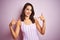 Young beautiful woman wearing striped pink swimsuit swimwear over pink  background looking confident with smile on face,