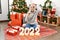 Young beautiful woman with white modern hair standing by christmas tree celebrating 2022 new year stressed and frustrated with