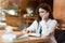 Young beautiful woman in white stylish jacket working on project outside office writing in planner during coffee break in cafe