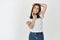 Young beautiful woman in white t-shirt dreamy looking up, posing on studio background