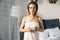 Young beautiful woman wrapped up with bath towel standing with coffee