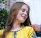 young beautiful woman, young girl in big city in yellow embroidered shirt, embroidered blouse, long brown hair, smile