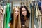 Young beautiful women at the cloth store. Best friends sharing free time having fun and shopping at the mall.