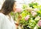 young beautiful women gardener sniffs hydrangea flowers in greenhouse.