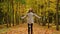 Young beautiful women wandering in the park in autumn holding leaf bouquet turning around throwing leaves