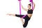 Young beautiful yogi woman doing aerial yoga practice in purple hammock on a white isolate