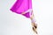 Young beautiful yogi woman doing aerial yoga practice in purple hammock on a white isolate