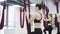 Young beautiful yogi women doing aerial yoga practice in red hammock in fitness club