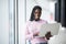 Young beauty afro american student woman holding open laptop on panoramic windows University background