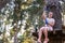 Young beauty female woman adult wears protective helmet having fun in extreme rope park, amusement park. Sitting in rope bridge at