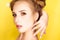 Young beauty girl with hair horns electic lamp hairstyle on a yellow background