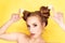 Young beauty girl with hair horns electic lamp hairstyle on a yellow background