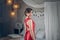 Young beauty woman, magnificent woman in evebing red dress, back view in a chic or luxury interior. the girl is going to a party