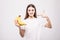 Young beauty woman pointed on bananas on white background. Health concept.