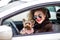 Young beauty woman in sunglasses and small dog yorkshire terrier in clothes in car. Funny dog traveling. Vacation with pet concept