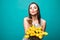 Young beauty woman with yellow tulips send air kiss isolated on green background