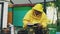 Young beekeeper man write in notepad checking harvest while sitting near beehives