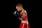 Young beginner boxer, sportive boy training isolated over dark background. Concept of sport, movement, studying