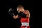 Young beginner boxer, sportive boy training isolated over dark background. Concept of sport, movement, studying