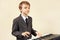 Young beginner musician in suit playing the electronic organ