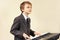 Young beginner musician in suit playing the electronic synth