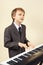 Young beginner musician in suit playing the synthesizer