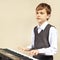 Young beginner pianist play the keys of synthesizer