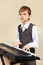 Young beginner pianist in a suit play the keys of electronic synth