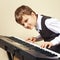 Young beginner pianist in suit playing the electronic piano