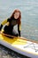 Young beuatiful redhead surfer female making preparation for surf session