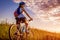 Young bicyclist riding in summer field. Healthy lifestyle concept
