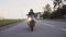 A young biker in a leather jacket and a helmet riding at the motorcycle along the highway around the city. Close-up