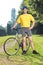 Young biker posing with his bicycle in a park