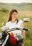 Young biker woman on the country road