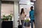 Young biracial business colleagues talking while walking together with luggage at airport