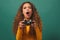 Young biracial woman plays game with console girl gamer, green studio background