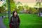 Young biracial woman walking alone at lake park at dusk